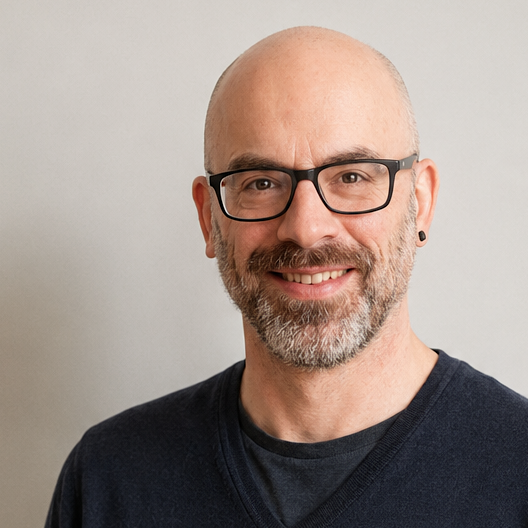 Björn Andresen smiling, wearing glasses and a dark jacket